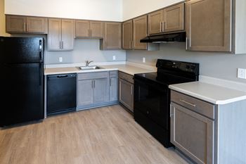 A kitchen with black appliances and wooden cabinets